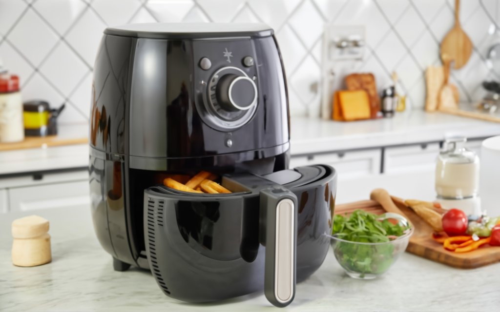  An air fryer being set up on a kitchen counter, focusing on its basket and control panel, with a kitchen backdrop